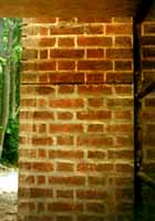 A mechanical grinder improperly used to cut out the horizontal joint and incompatible repointing have seriously damaged the 19th century brick.